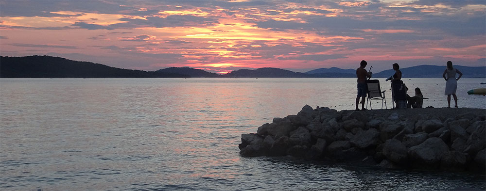 De kust van Dalmatië bij ondergaande zon